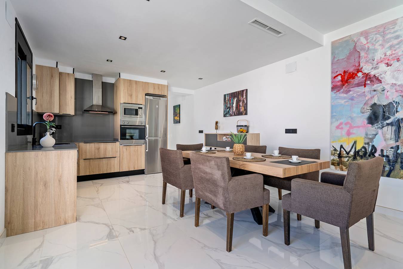 Comedor exterior bajo pérgola cubierta junto a la piscina