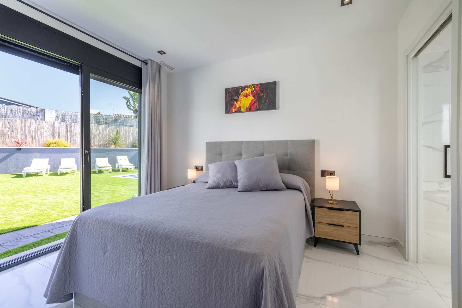 Suite principal con cama doble y vistas al jardín en La Villa del Roc, Roda de Berà